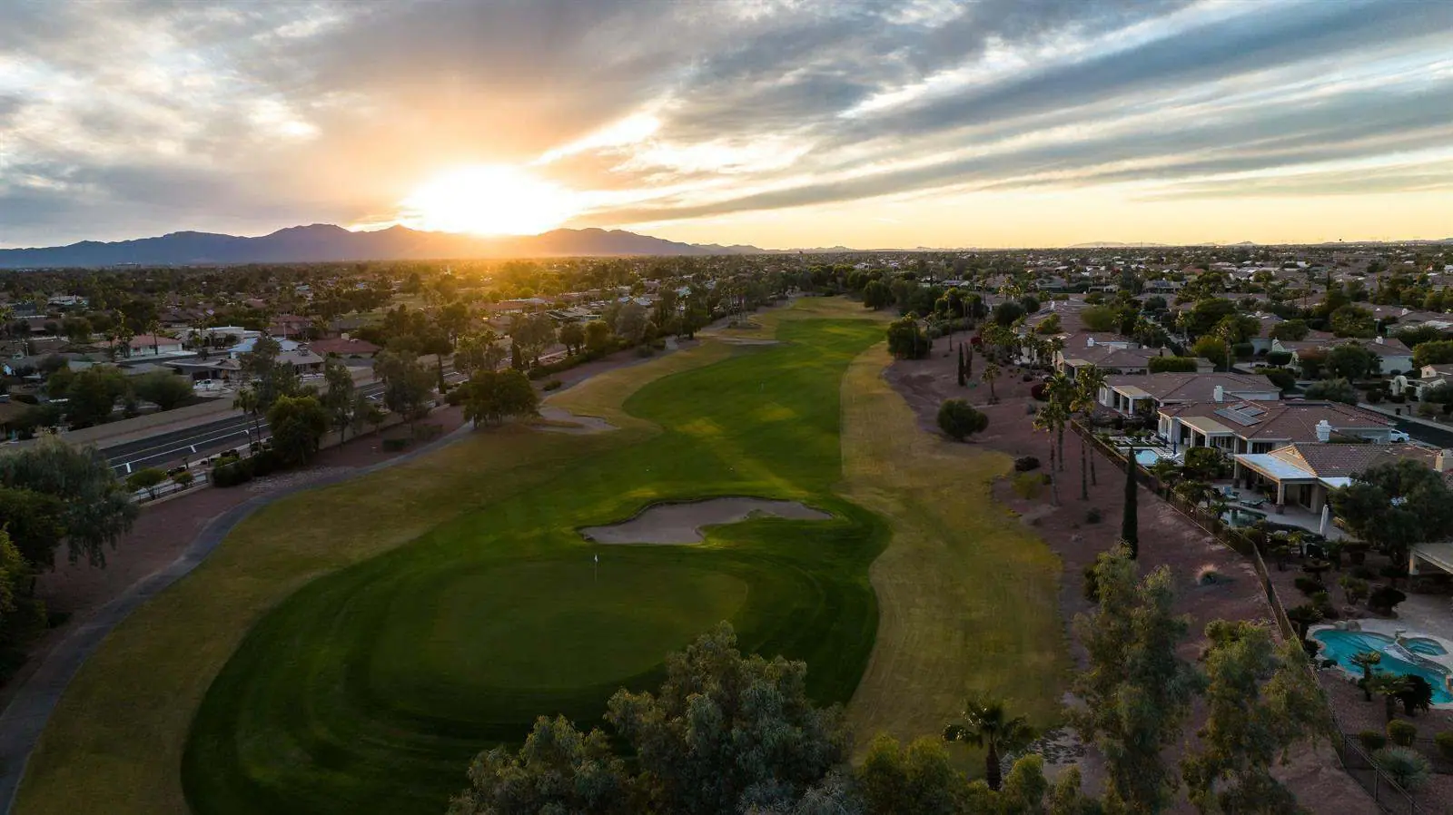 Aerial view of a golf course fairway and homes at sunset, the communities covered by the Arizona community floor plans