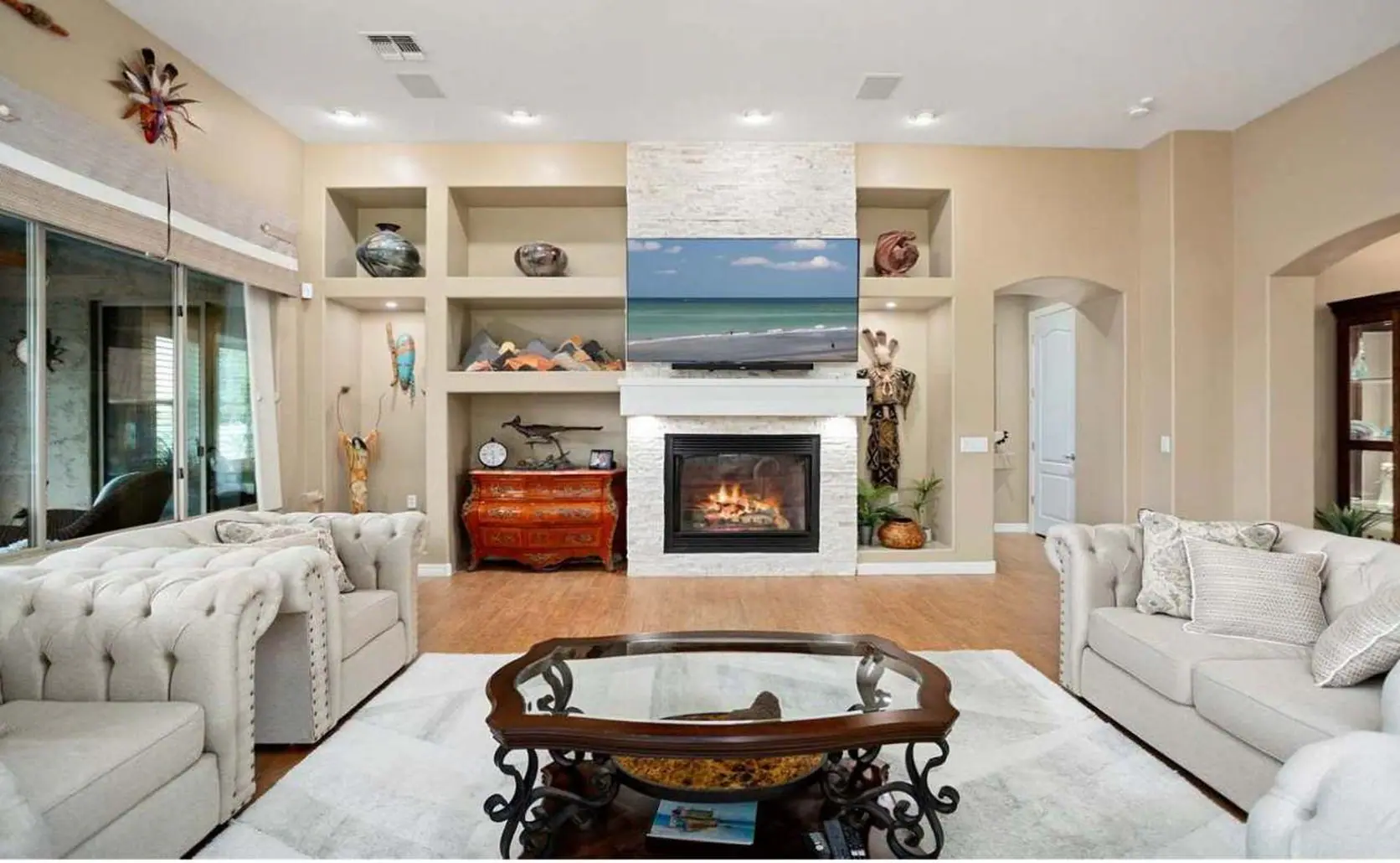 Living room with a fireplace, tufted sofas and a glass coffee table, a home listed with the Arizona Seller Form Book